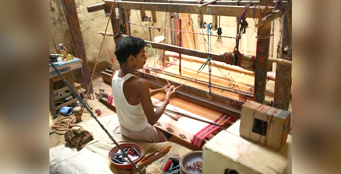 Traditional Indian textile artisan weaving on handloom